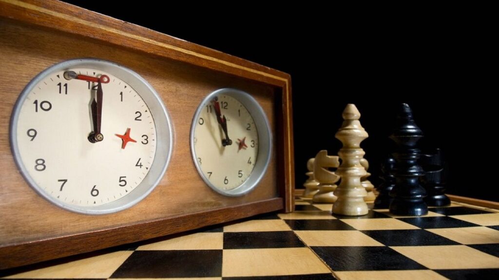 Reloj de ajedrez con piezas al lado